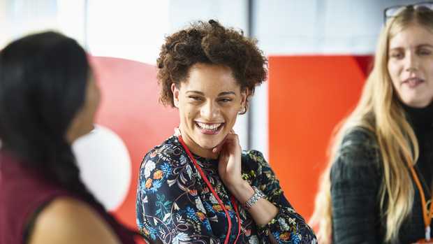 close-up of two student of different ethnicities laughing during group discussion